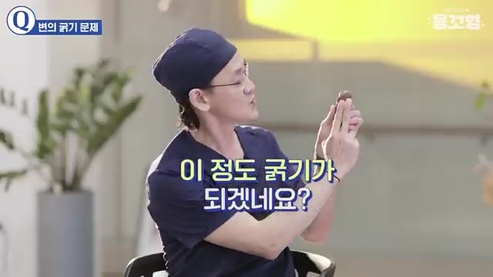 손가락으로 변의 굵기를 가늠해 보이며 이 정도 굵기가 되겠네요 하고 말하는 장면